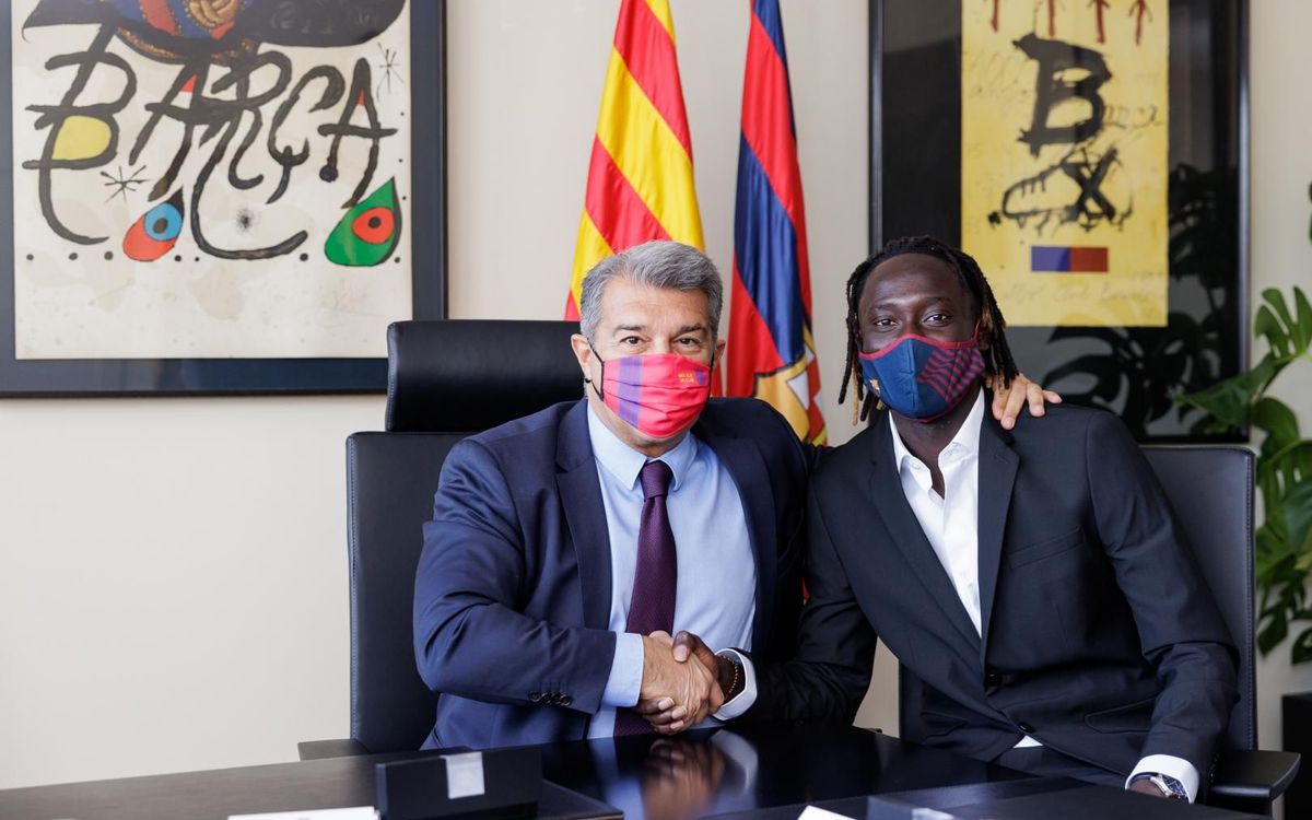 Alpha Diounkou firma con el presidente Joan Laporta