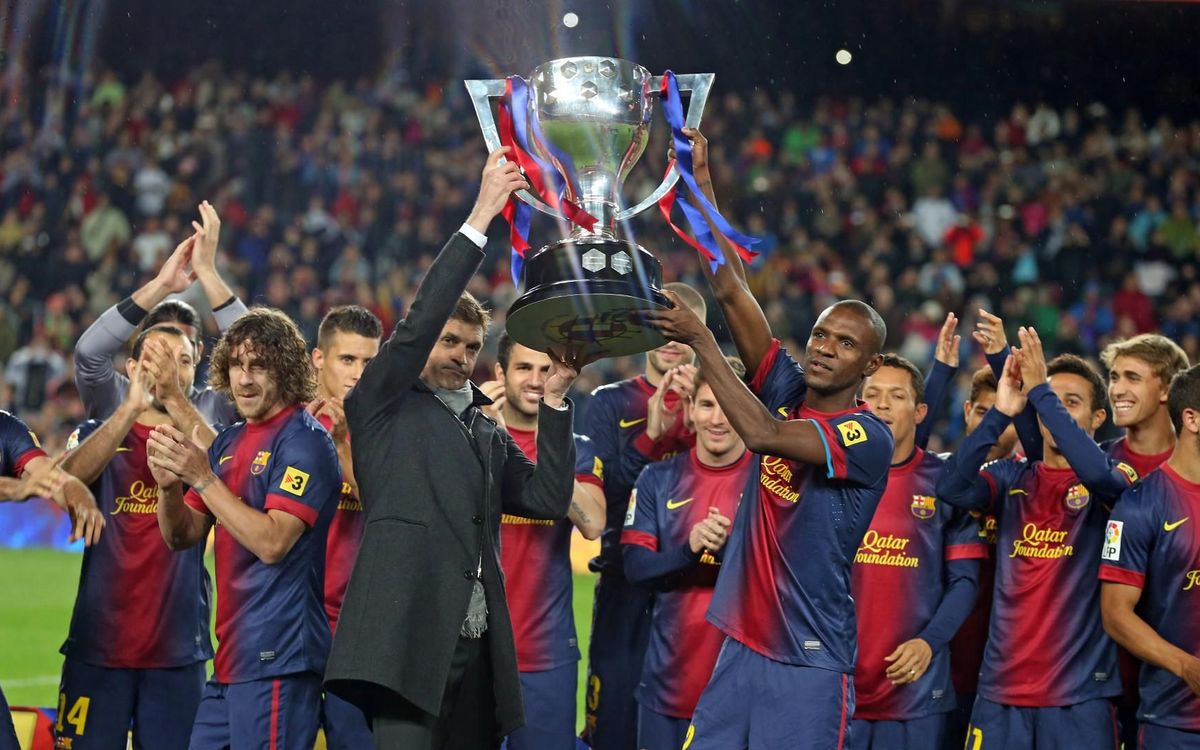 Tito Vilanova i Éric Abidal aixequen el trofeu de campions de la 'Lliga dels 100 punts', la temporada 2012/13